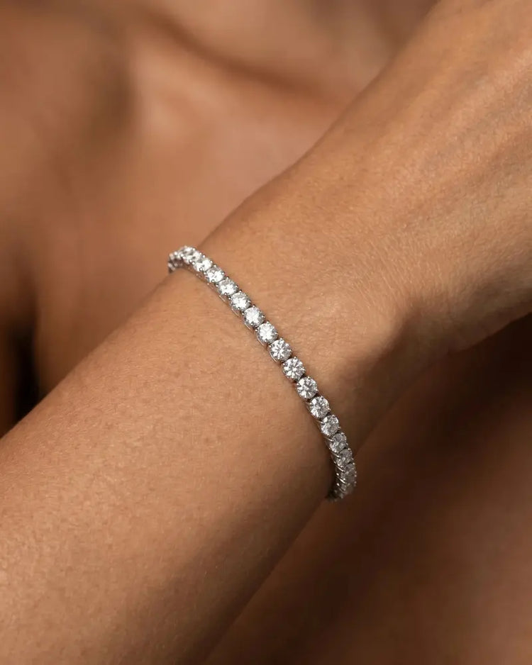 Nærbilde at et tennisarmbånd i hvitt gull med 5 carat diamanter på armen til modell
