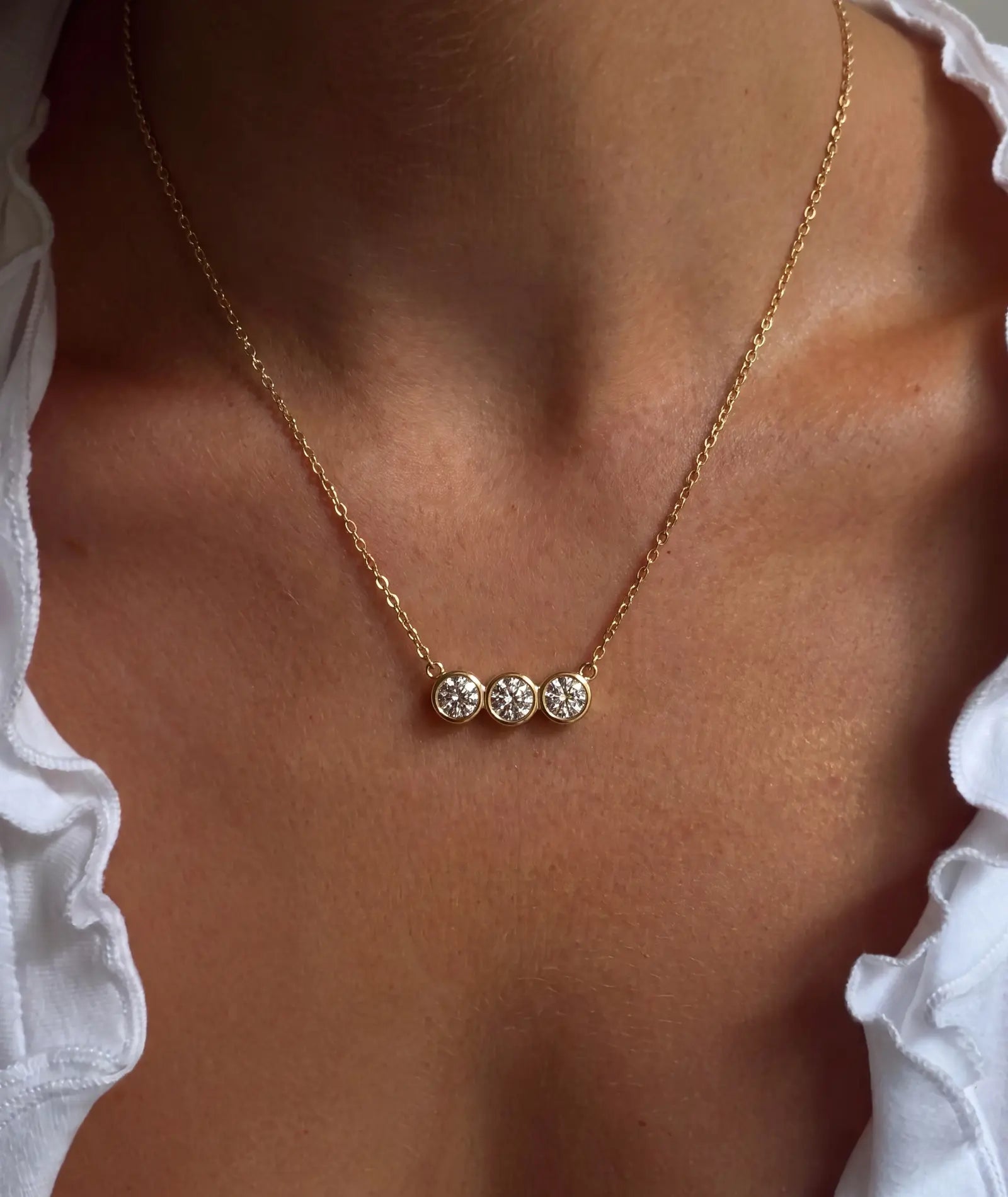 Tre-stens diamanthalskjede i bezelinnfatning, 14K gult gull.