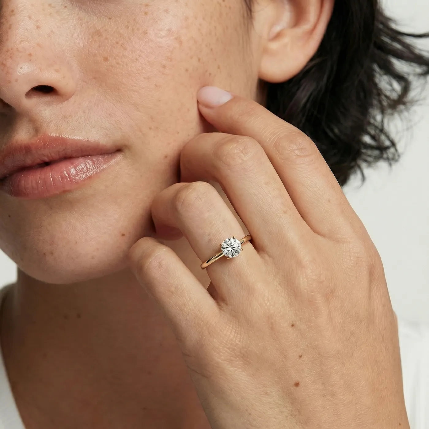 0,50 ct tynn diamantring i gult gull med lab diamant vist på modell i naturlig lys