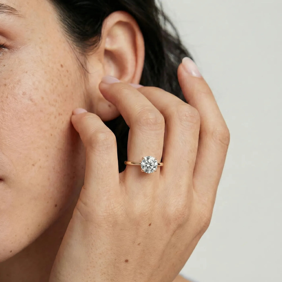 1 ct tynn diamantring i rosegull med lab diamant vist på modell i naturlig lys