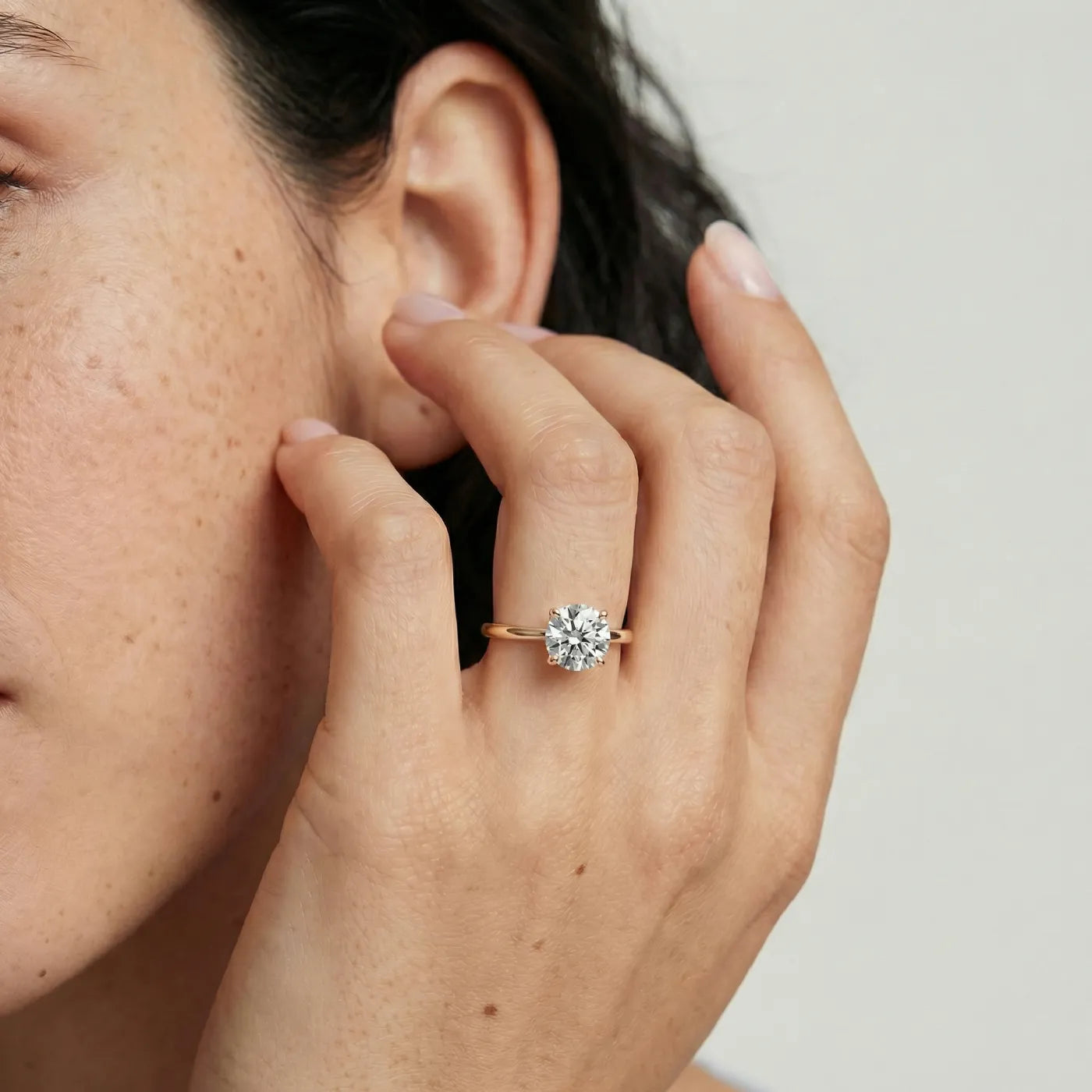 1 ct tynn diamantring i rosegull med lab diamant vist på modell i naturlig lys