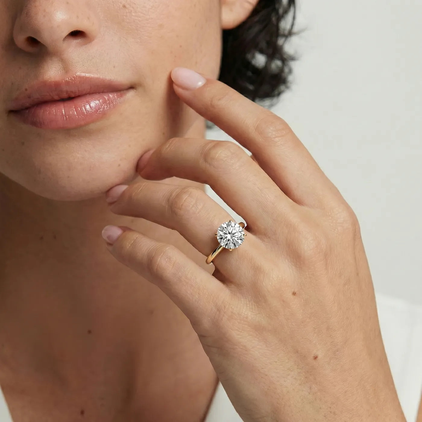 2 ct tynn diamantring i gult gull med lab diamant vist på modell i naturlig lys