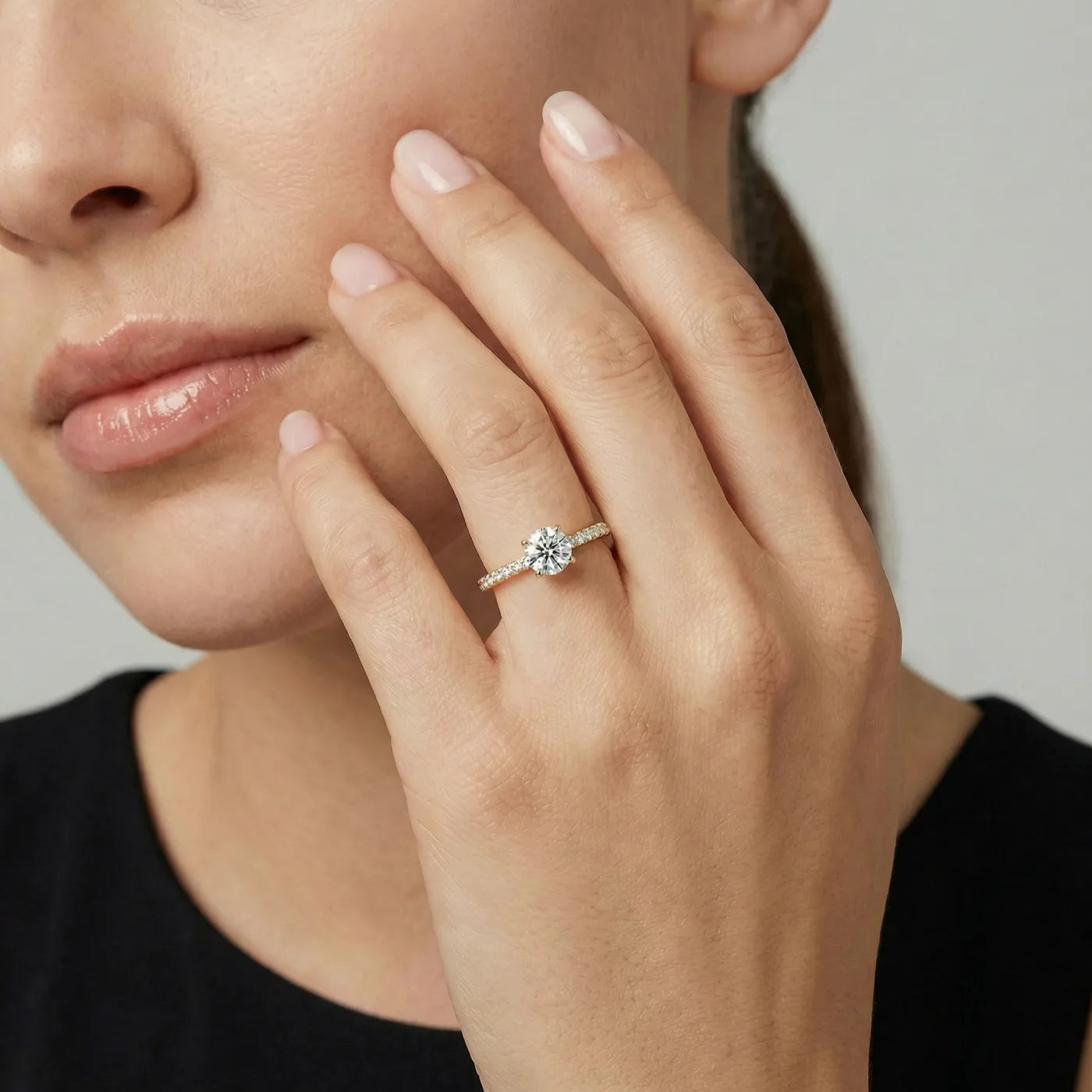 Tynn diamantring i gult gull med pave diamanter 0,76 carat på modell i naturlig lys.
