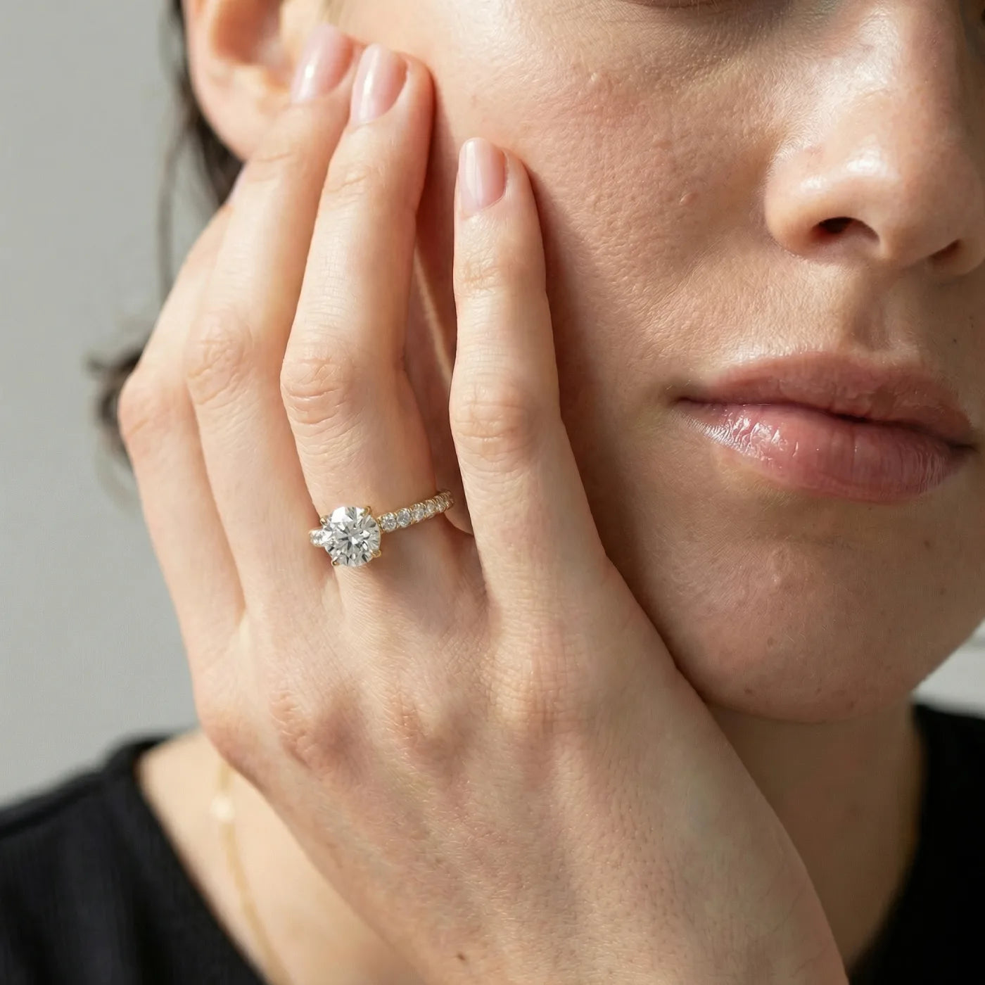 Tynn diamantring i  gult gull med pave diamanter 1,30 carat på modell i naturlig lys.